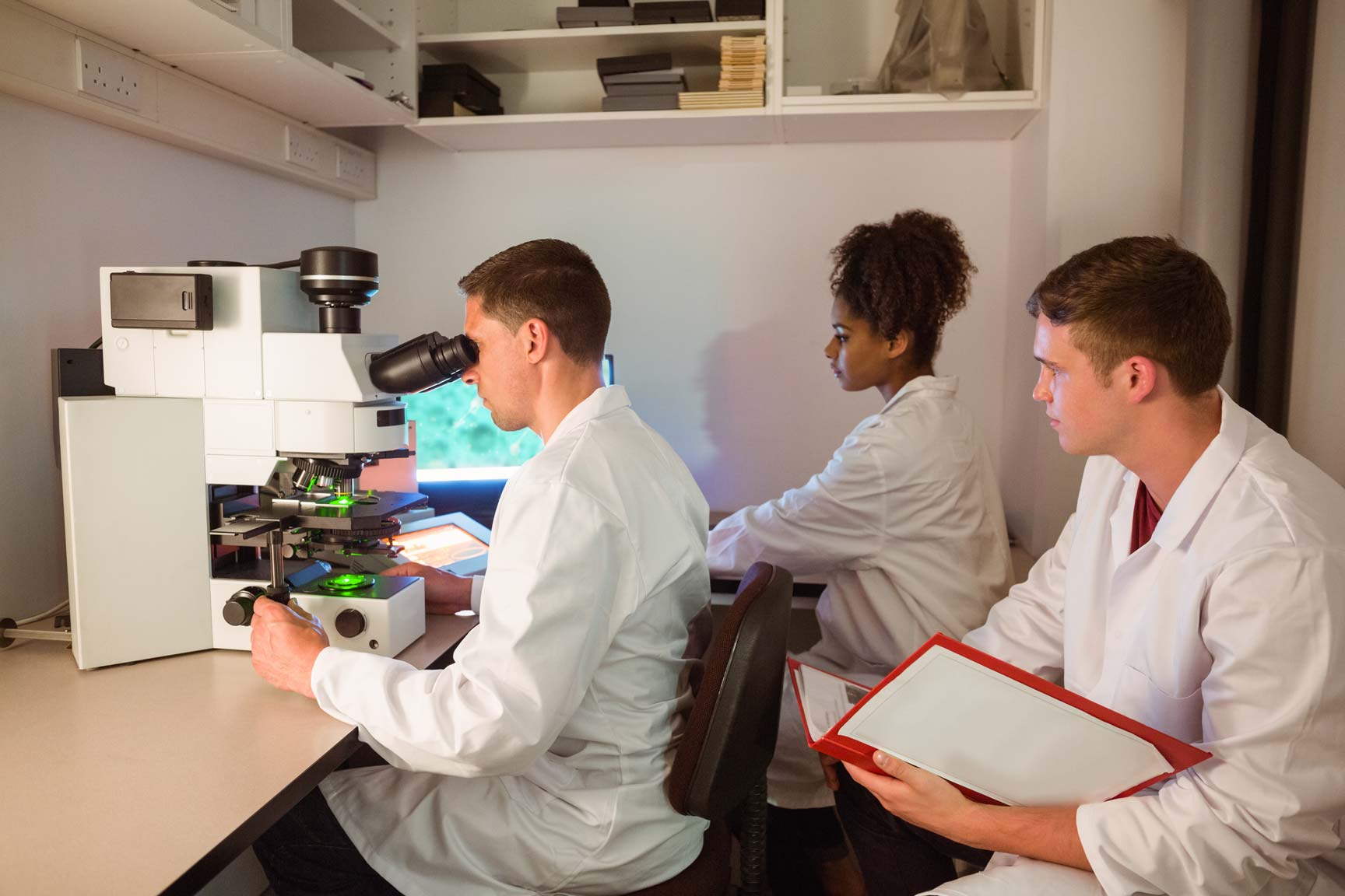 Laboratory professionals reviewing a specimen at the microscope